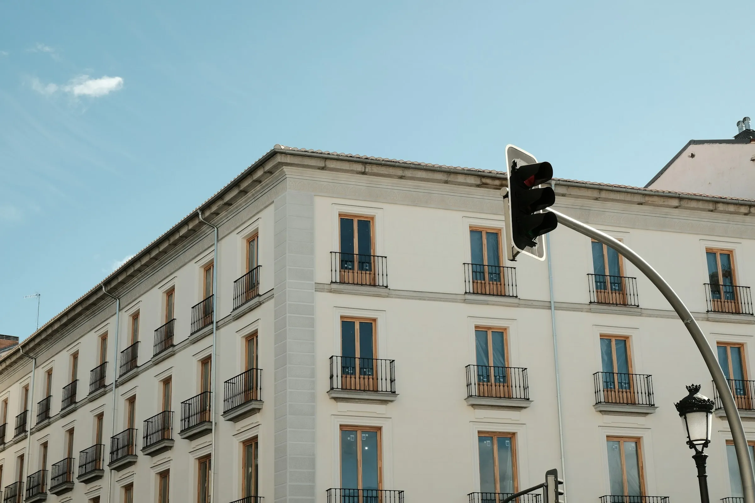 Bloque de viviendas de ensanche en Madrid, con balcones de forja y cielo despejado